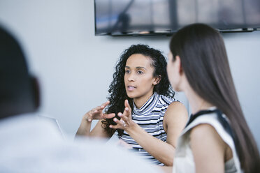 Eine Geschäftsfrau erklärt ihren Kollegen in einer Sitzung im Sitzungssaal - CAVF29002