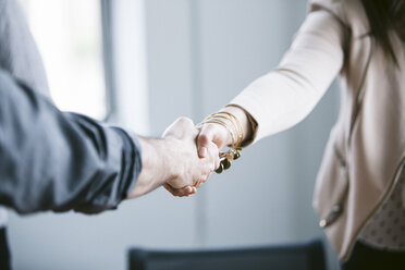 Midsection of business people shaking hands in board room - CAVF29008