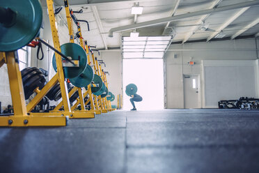 Seitenansicht einer Frau beim Gewichtheben in einem Fitnessstudio - CAVF29118