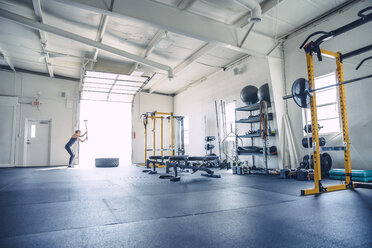 Frau hämmert Reifen beim Training im Fitnessstudio - CAVF29125