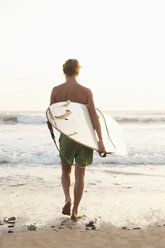Jugendlicher mit Surfbrett auf dem Weg zum Meer in Costa Rica - FOLF01360
