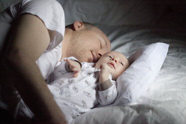 Father with baby son relaxing on bed - FOLF01368