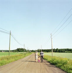 Rear view of people with child walking along dirt road - FOLF01438