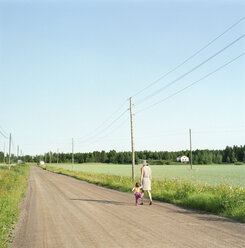 Mother and daughter walking along dirt road - FOLF01439