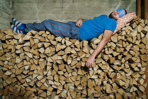 Man sleeping on pile of firewood - FOLF01449