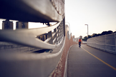 Man cycling on bridge against clear sky - CAVF29163