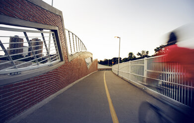 Unscharfes Bild eines Radfahrers auf einer Brücke bei klarem Himmel - CAVF29165