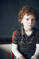 Porträt eines Jungen, der in der Schule vor einer Tafel sitzt - CAVF29194