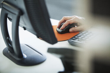 Abgeschnittenes Bild einer Frau, die einen Computer am Schreibtisch benutzt - CAVF29229