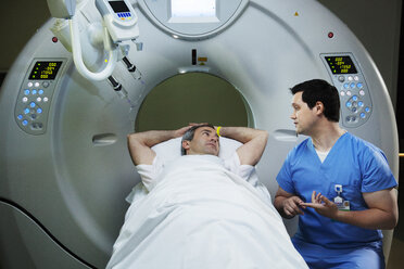 Ein Patient liegt auf einem CAT-Scan-Gerät und spricht mit einem Radiologen im Krankenhaus - CAVF29250
