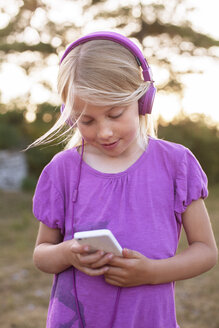 Mädchen hört Musik auf einem Smartphone - FOLF01464