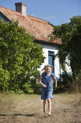 Girl running across back yard - FOLF01469