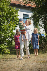 Mutter mit Töchtern und Sohn im Hinterhof - FOLF01470