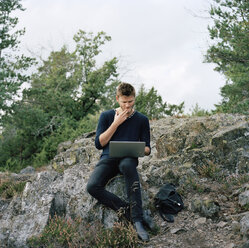 Mann benutzt Laptop im Wald - FOLF01578