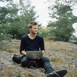 Mann benutzt Laptop im Wald - FOLF01582