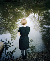 Junge Frau steht am Rande eines Sees - FOLF01621