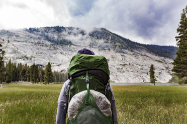 Wanderer mit Rucksack beim Blick auf einen Berg im Yosemite-Nationalpark - CAVF29361