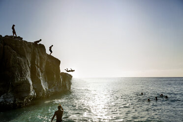 Freunde springen von einer Klippe ins Meer gegen den Himmel - CAVF29369