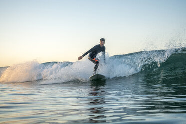 Man surfing on huge waves in sea against clear sky - CAVF29396