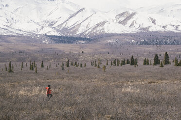 High angle view of woman walking on field against snowcapped mountains at Denali National Park - CAVF29427