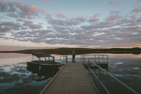 Mann steht auf Pier über Fluss gegen bewölkten Himmel bei Sonnenuntergang, lizenzfreies Stockfoto