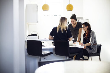 Business people discussing at cafeteria in office - CAVF29437