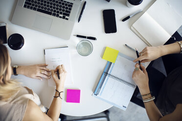 Draufsicht auf Geschäftsfrauen, die am Tisch in einem kreativen Büro planen - CAVF29455