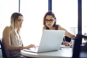 Geschäftsfrauen mit Laptop im kreativen Büro sitzend - CAVF29458