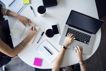 Draufsicht auf Geschäftsfrauen, die an einem Tisch in einem kreativen Büro arbeiten - CAVF29460