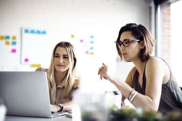 Geschäftsfrauen diskutieren bei der Verwendung eines Laptops im Kreativbüro - CAVF29461