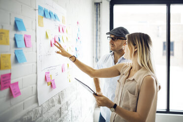 Business people planning over adhesive notes at creative office - CAVF29522