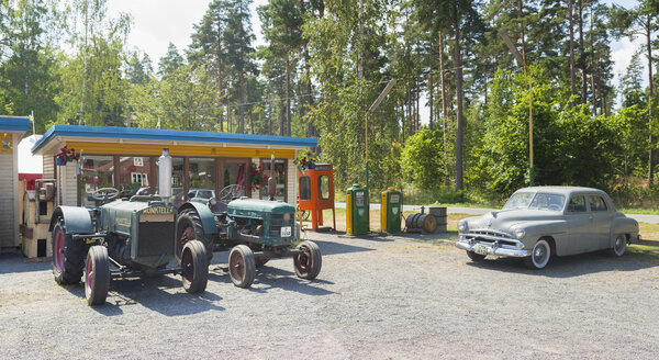 Altmodisches Auto und Traktoren in einer Tankstelle - FOLF01744
