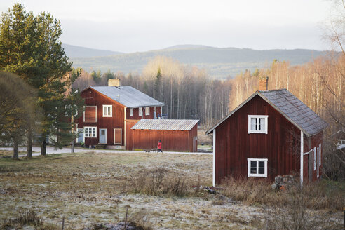 Rote Holzhäuser in herbstlicher Landschaft - FOLF01838