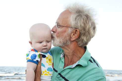 Mann hält und küsst seinen Enkel - FOLF01911