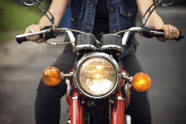 Midsection of woman riding motorcycle on road - CAVF29582