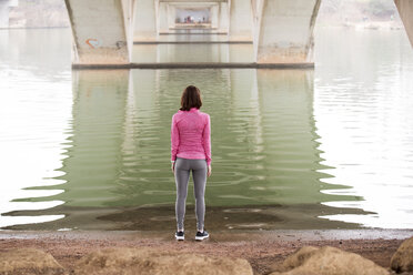 Rear view of woman exercising at lakeshore below Lamar Boulevard Bridge - CAVF29644