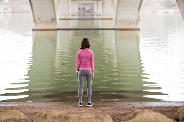 Rückansicht einer Frau beim Sport am Seeufer unterhalb der Lamar-Boulevard-Brücke - CAVF29644