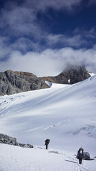 Männer wandern auf schneebedecktem Berg gegen den Himmel - CAVF29761