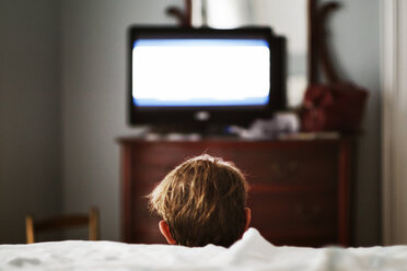 Rückansicht eines Jungen beim Fernsehen zu Hause - CAVF29805