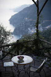 Fruit bowl on table at resort patio with mountains in background - CAVF29825