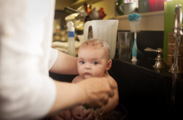 Abgeschnittenes Bild einer Person, die ein kleines Mädchen im Badezimmer badet - CAVF29849