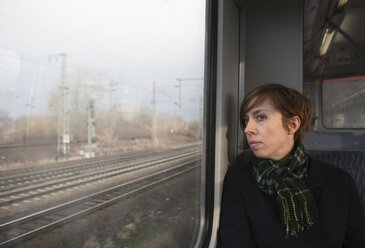 Mittlere erwachsene Frau im Zug schaut durch das Fenster - FOLF02064