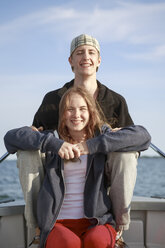 Portrait of teenage girl and young man sitting on boat - FOLF02108