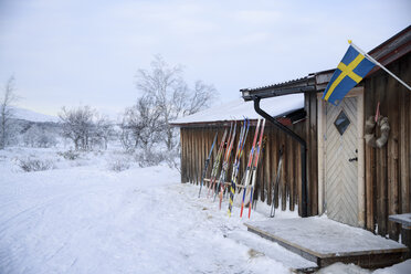 Skier lehnen im Winter an einem Holzchalet - FOLF02116