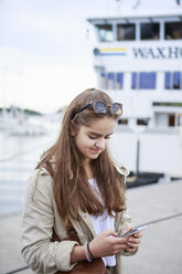 Teenager-Mädchen benutzt ein Smartphone - FOLF02121