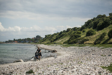 Frau mit Kinderwagen geht an der Küste entlang - FOLF02234