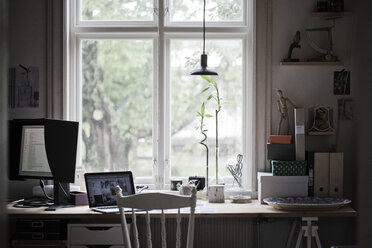 Schreibtisch mit Laptop und Computerbildschirm am Fenster - FOLF02239