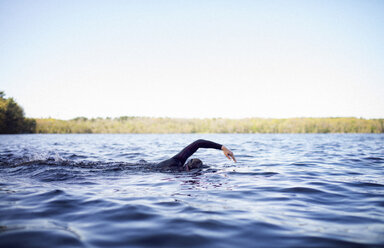 Woman swimming in lake against clear sky - CAVF29969