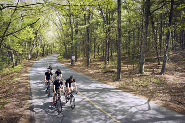 High angle view of male cyclists riding bicycles on country road - CAVF29993