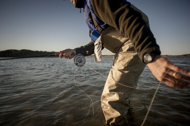 Cropped image of man fishing at sea against clear sky - CAVF30004